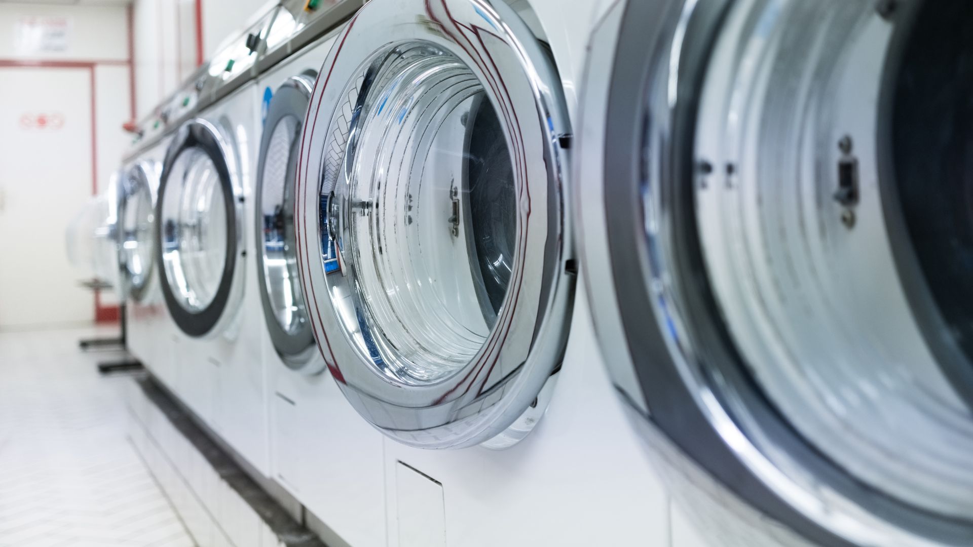 Row of industrial washing machines in a laundromat or cleaning facility